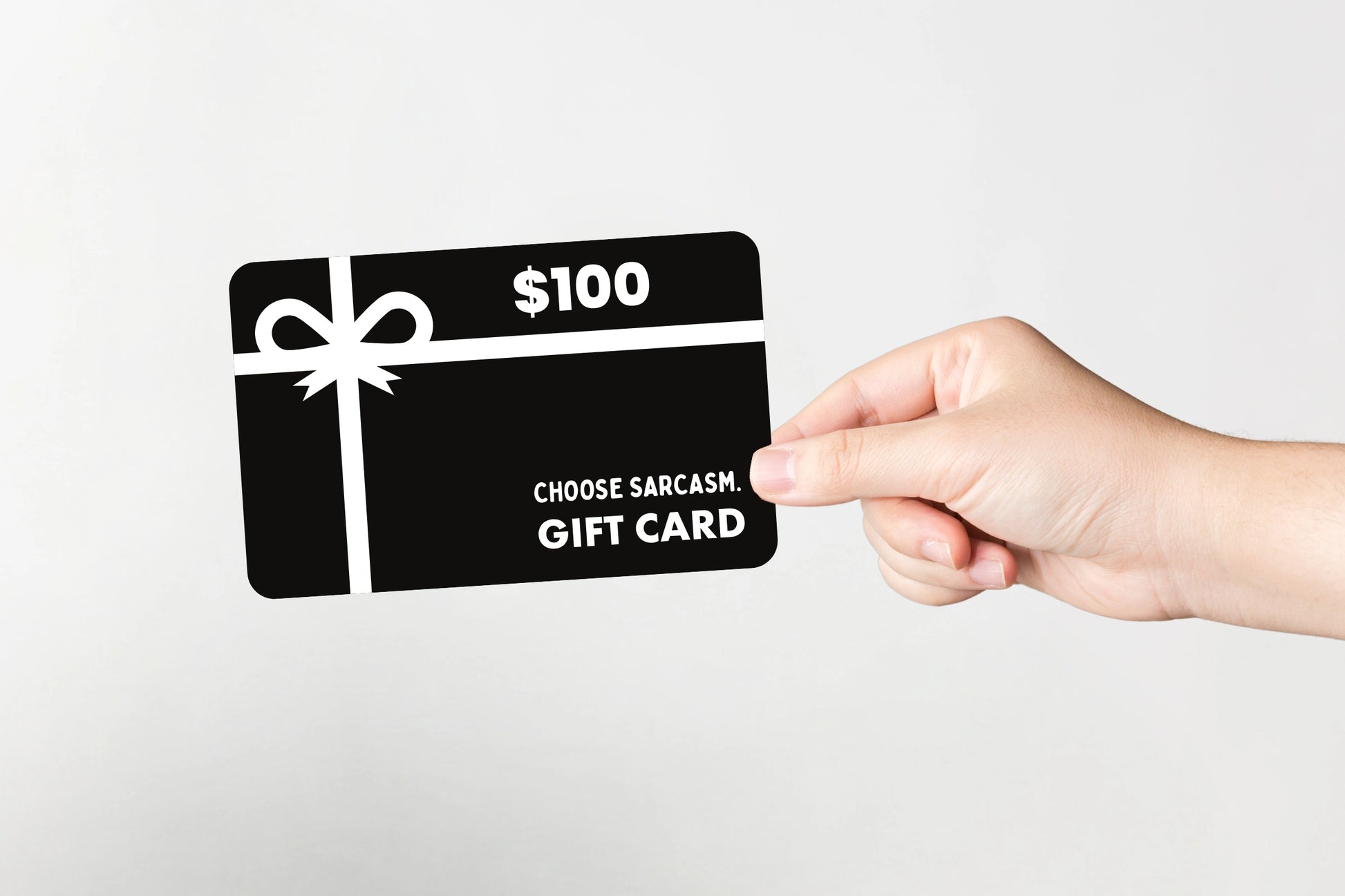 Flat lay of CHOOSE SARCASM gift card valued at $100.